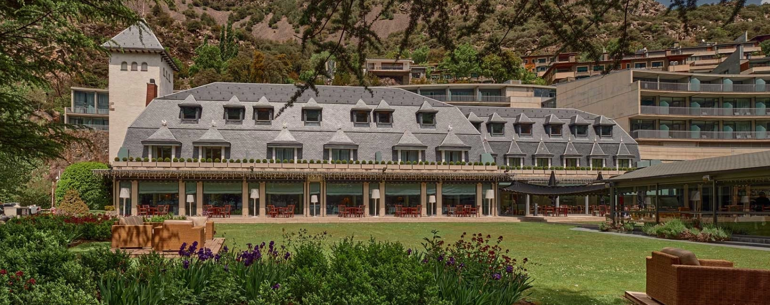 Andorra Park Hotel Su proximidad a la principal arteria comercial del país, The Shopping Mile, y a los principales centros de ocio de la capital es, sin duda, uno de los puntos fuertes del hotel. Podrás disfrutar de las mejores actividades de ocio y de la experiencia de compras en las tiendas más exclusivas de la capital. Cuenta con 95 habitaciones sofisticadas, confortables y exquisitamente decoradas. Madera, piel, textiles suaves y una paleta cromática que reproduce el imponente exterior. Sus acogedoras suites tienen acceso al jardín aromático y a 15.000 m2 de parque natural, una combinación perfecta de un paisaje único con una decoración cálida y serena.  Sus propuestas gastronómicas ofrecen un regalo para los sentidos. En su restaurante La Pérgola, el chef Marc Mora recrea los sabores populares y clásicos reinterpretando la cocina andorrana, francesa y mediterránea, con su secreto: las hierbas aromáticas del jardín. Unas creaciones perfectamente maridadas por el sumiller Ramón Cabiscol que, con más de 300 referencias en la bodega, te propondrá un viaje por los mejores viñedos del mundo. Y para los amantes de los dulces, en La Pâtisserie, el chef pastelero Patrice Bernard sugerirá una galería de esculturas dulces y comestibles donde sucumbir al placer de una repostería ultracreativa, colorista y de diseño. En sus instalaciones, el hotel cuenta con un club de wellness con diferentes espacios de bienestar para relajarse y disfrutar de un momento de calma. Spa, cabinas de masajes, carta exclusiva de tratamientos, piscina, sauna, sala de fitness o pistas de pádel son algunos de los espacios que ofrece el hotel. Además, el hotel es miembro del Andorra Health Destination, ofreciéndote total garantía de la calidad de los tratamientos y terapias que te recomiendan. El Andorra Park Hotel, uno de los primeros hoteles de 5 estrellas del país, te ofrece un servicio personalizado al mínimo detalle. El equipo del Andorra Park Hotel apuesta por la calidad y la atención al mínimo detalle, que son señales de identidad siempre presentes en la atmósfera del hotel.  