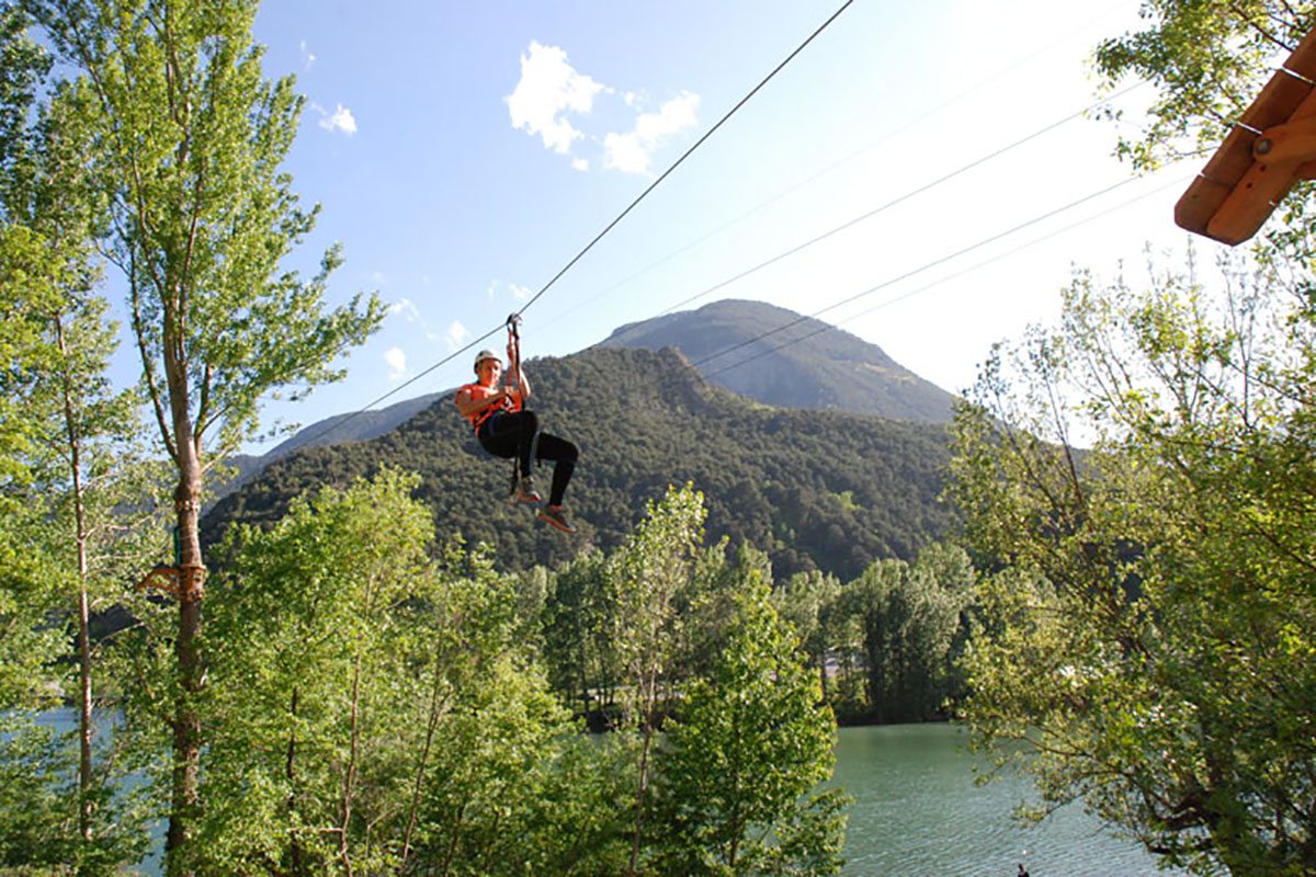 Descubre el emocionante Parque de Aventuras Naturaran en el Val d’Aran: ¡Aventura entre árboles! ¿Buscas un plan emocionante para disfrutar en familia o con amigos?' ¡No busques más! En el bonito pueblo de Les, en la Val d'Aran, a 20 minutos de Vielha,te espera nuestro increíble Parque de Aventuras Naturaran. Diseñado para todas las edades y niveles de habilidad. Nuestro parque cuenta con una amplia gama de opciones para que todos puedan tener su propia dosis de adrenalina! Los más pequeños de la casa pueden disfrutar de nuestro Circuito Infantil especialmente diseñado, equipado con medidas de seguridad pasiva para su tranquilidad y protección. Si eres un aventurero experimentado, nuestros 4 circuitos multiaventura te desafiarán y te brindarán una experiencia emocionante. Supera obstáculos, prueba tu equilibrio y siente la emoción mientras te mueves entre las copas de los árboles. ¡La diversión está garantizada! Pero eso no es todo. Para aquellos que buscan una experiencia aún más emocionante, ofrecemos un circuito de tirolinas que te hará volar por el aire. Imagina la sensación de libertad mientras surcas los cielos y admiras la impresionante belleza natural que te rodea. Y para los amantes de las emociones fuertes, contamos con una tirolina gigante de 250 metros que te dejará sin aliento. En nuestro Parque de Aventuras Naturaran del Val d'Aran, la seguridad es nuestra máxima prioridad. Contamos con un equipo de profesionales altamente capacitados que supervisan constantemente las instalaciones y se aseguran de que todos los visitantes estén protegidos en todo momento. Así que no pierdas la oportunidad de disfrutar de un magnífico día en familia o con amigos en nuestro Parque de Aventuras del Val d'Aran. ¡Ven y únete a la diversión! ¡Te esperamos con los brazos abiertos para vivir una experiencia inolvidable en medio de la naturaleza! Detalles de la actividad CIRCUITO INFANTIL para niños menores de 9 años o con menos de 135 cm de altura CIRCUITO AMARILLO + TIROLINA GIGANTE: Personas con más de 135 cm de altura, menos de 195 cm y menos de 95 kg. 4 CIRCUITOS MULTIAVENTURA + TIROLINA GIGANTE: Personas con más de 155 cm de altura, menos de 195 cm y menos de 95 kg. 4 CIRCUITOS MULTIAVENTURA + CIRCUITO DE TIROLINAS + TIROLINA GIGANTE: Personas con más de 155 cm de altura, menos de 195 cm y menos de 95 kg. Del Abril a Junio, grupo mínimo 4 pax. Horario 10h30 De Julio a Septiembre abierto todos los días de 10h30 a 13h30 y 16h30 a 20h30