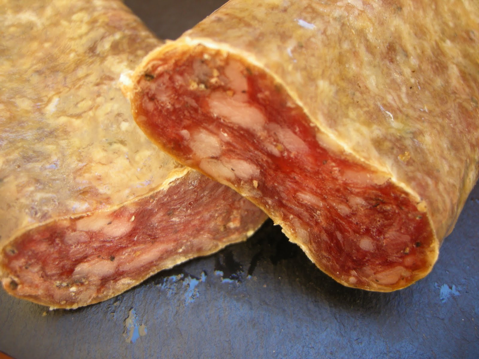 ‘Xolís’ del Pirineo, el embutido que se prepara con las partes nobles del cerdo Cal Tomàs, en La Pobla de Segur, es uno de los productores de un salchichón que se prepara con jamón, paletilla, lomo, un poco de tocino para dar jugosidad y un sencillo adobo de sal y pimienta. Teniendo en cuenta que los embutidos; a diferencia de los salazones como la cecina o el jamón, han sido históricamente una manera de conservar gran cantidad de grasa, sangre, manteca y otras partes menos refinadas -pero bien sabrosas, sobre todo una vez especiadas- del cerdo, el xolís del Pirineu es, de partida, un caso especial. Este salchichón curado, tradicional del Pallars Jussà y del Pallars Sobirà, en Lleida, está pensado para comer tal cual o acompañado con pan —aunque hay quien cocina con él, como veremos más adelante. “Nace de la voluntad de conservación, durante las matanzas de invierno, de algunas de las partes más nobles del cerdo”, nos cuentan Laura y Miquel Gordó, cuarta generación de carniceros de Cal Tomàs, uno de sus elaboradores estrella en La Pobla de Segur.